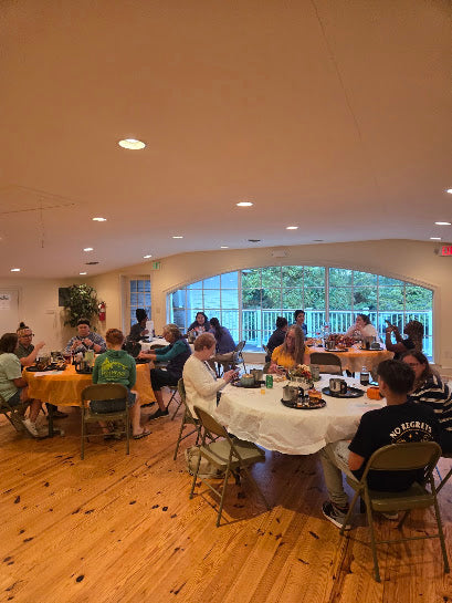 Group of guests holding hand-carved wood dough bowls at a Seven Divas Fall Candle Workshop